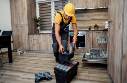 Young male plumber in kitchen